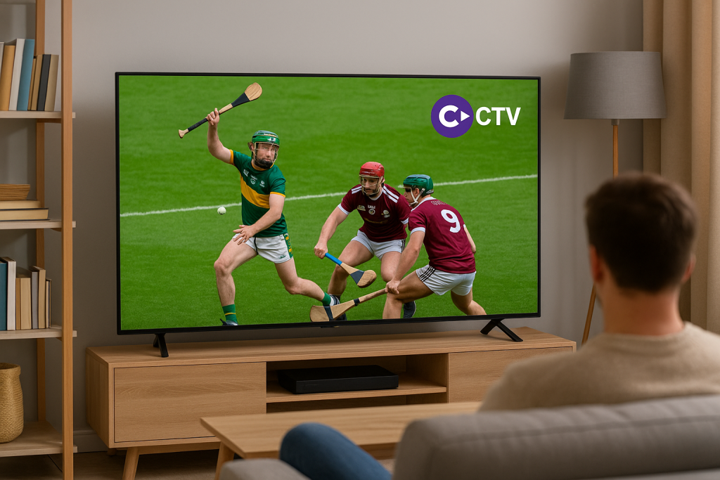 A modern living room with a wide-screen TV displaying a live hurling match streamed via Clubber TV Ireland, showing players in action with a GAA pitch background.